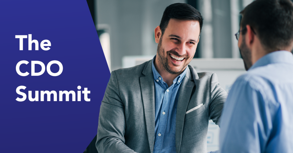 Smiling businessman in gray blazer shaking hands at professional event with 'The CDO Summit' text on blue background