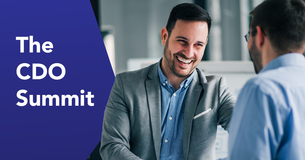 Smiling businessman in gray blazer shaking hands at professional event with 'The CDO Summit' text on blue background